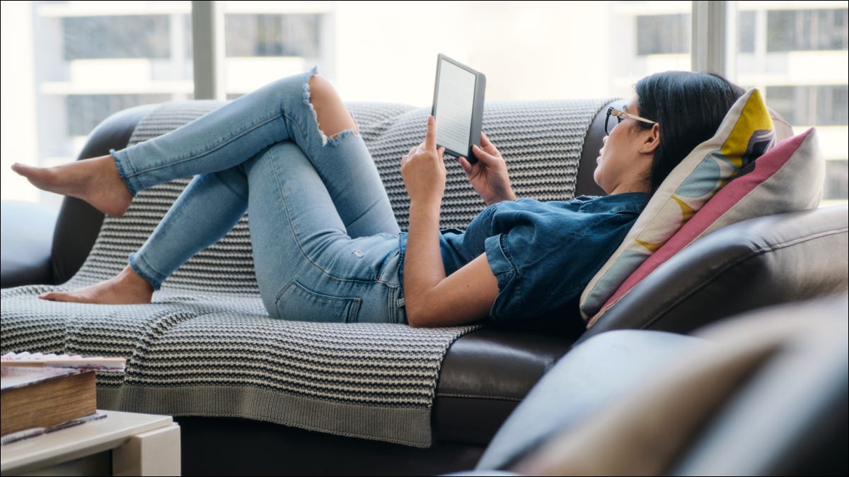 mulher deitada no sofá com ereader