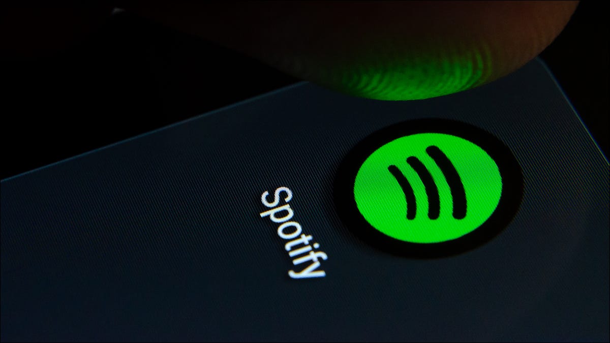 Pessoa tocando no logotipo do aplicativo Spotify em um smartphone