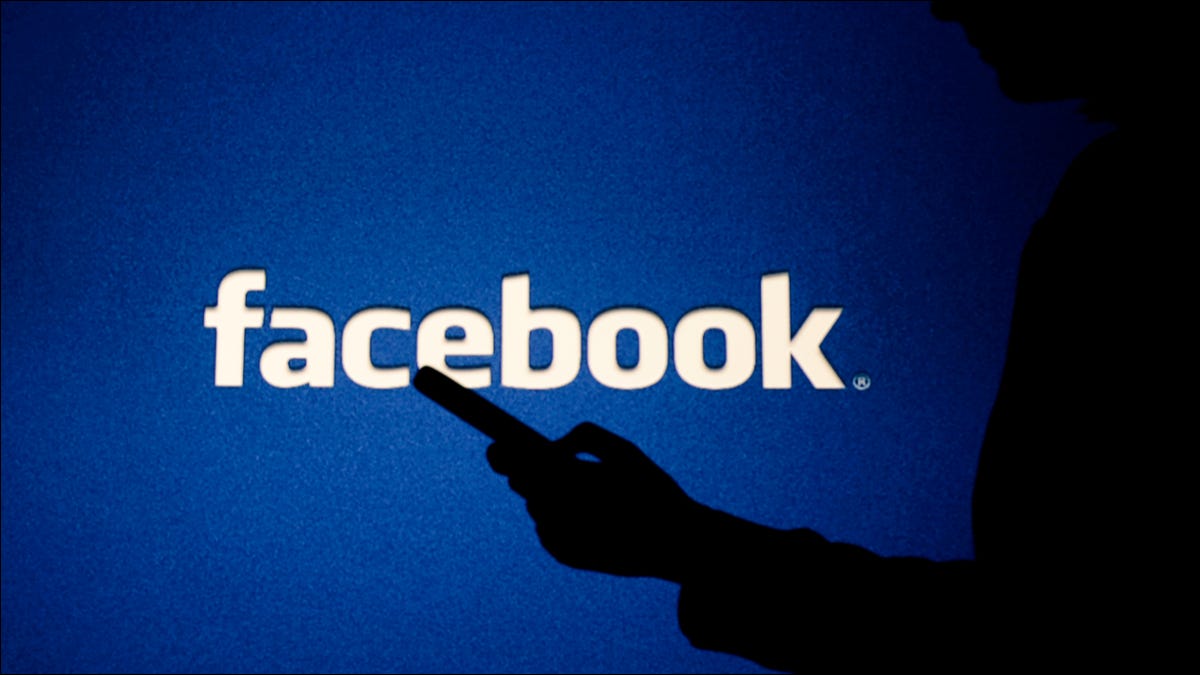 Uma figura sombria na frente de um logotipo do Facebook.
