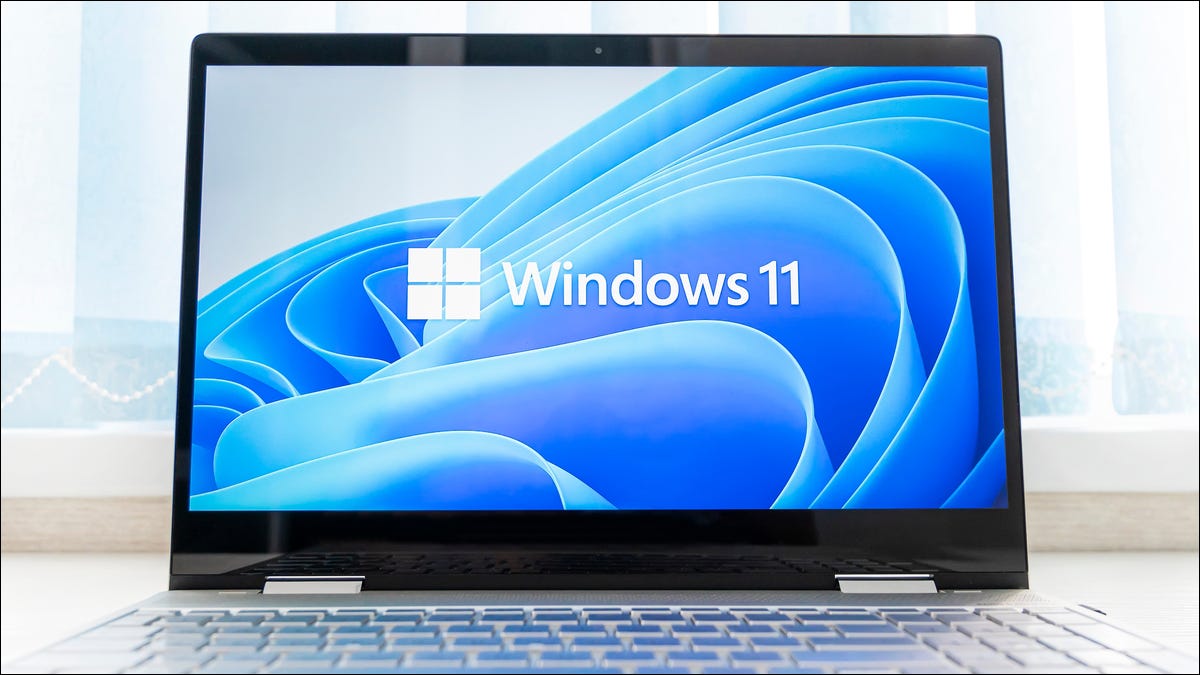 O logotipo do Windows 11 e o plano de fundo da área de trabalho em um laptop PC.