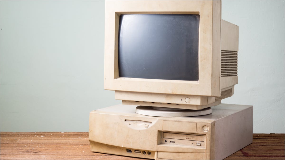Um computador obsoleto em uma mesa de madeira.