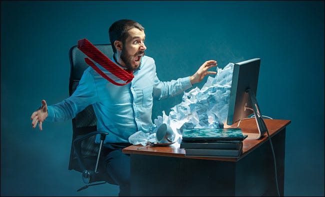 Ilustração fotográfica de um homem reagindo a spam proveniente de seu monitor.