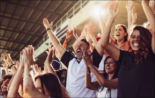 Fãs de esportes torcendo nas arquibancadas durante um jogo