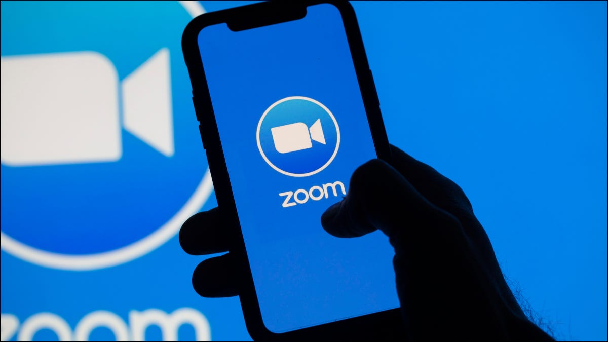 Smartphone mostrando o logotipo da Zoom sobre um fundo maior do logotipo da Zoom