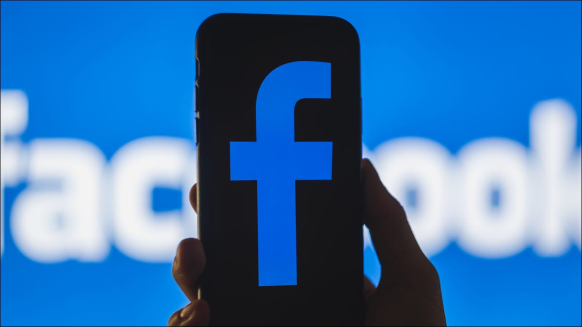 Um smartphone com uma versão escura do logotipo do Facebook na frente de um banner do Facebook
