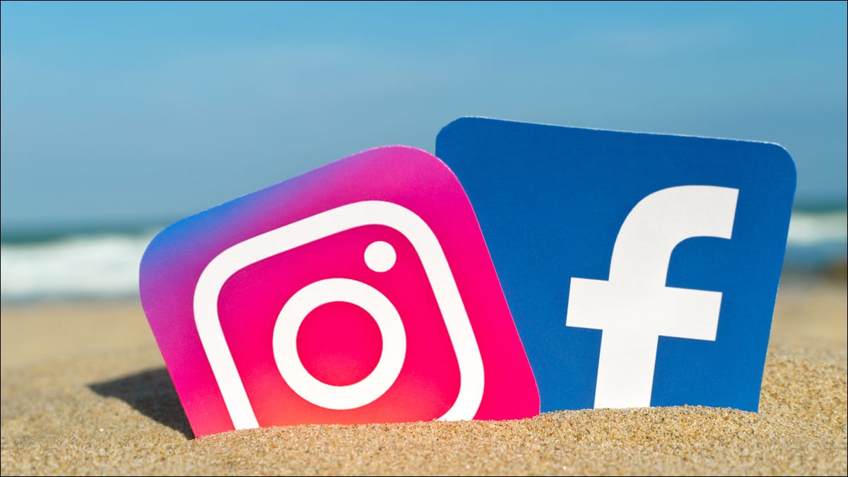 Recortes dos logotipos do Instagram e do Facebook presos na areia em uma praia ensolarada.