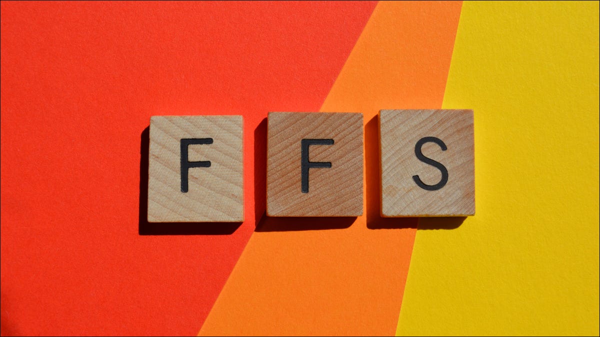 Títulos de letras de madeira soletrando "FFS" em um fundo laranja e amarelo.