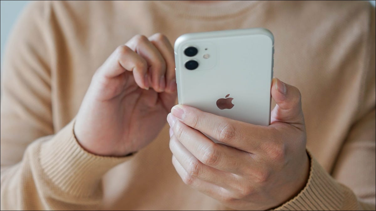 Closeup das mãos de um homem segurando um iPhone 11.