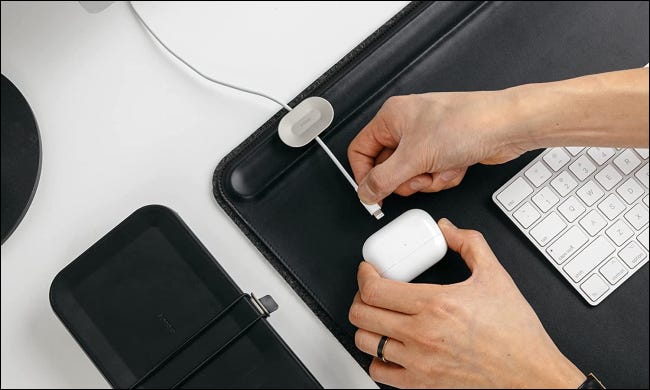 pessoa conectando AirPods no teclado da mesa Orbitkey