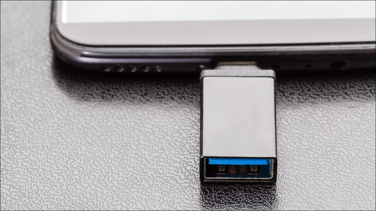 Smartphone com unidade USB OTG conectada.