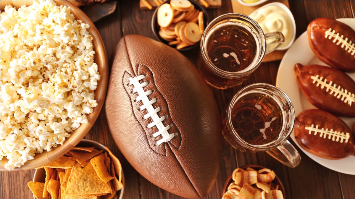 mesa com uma bola de futebol, lanches e bebidas sentado em cima