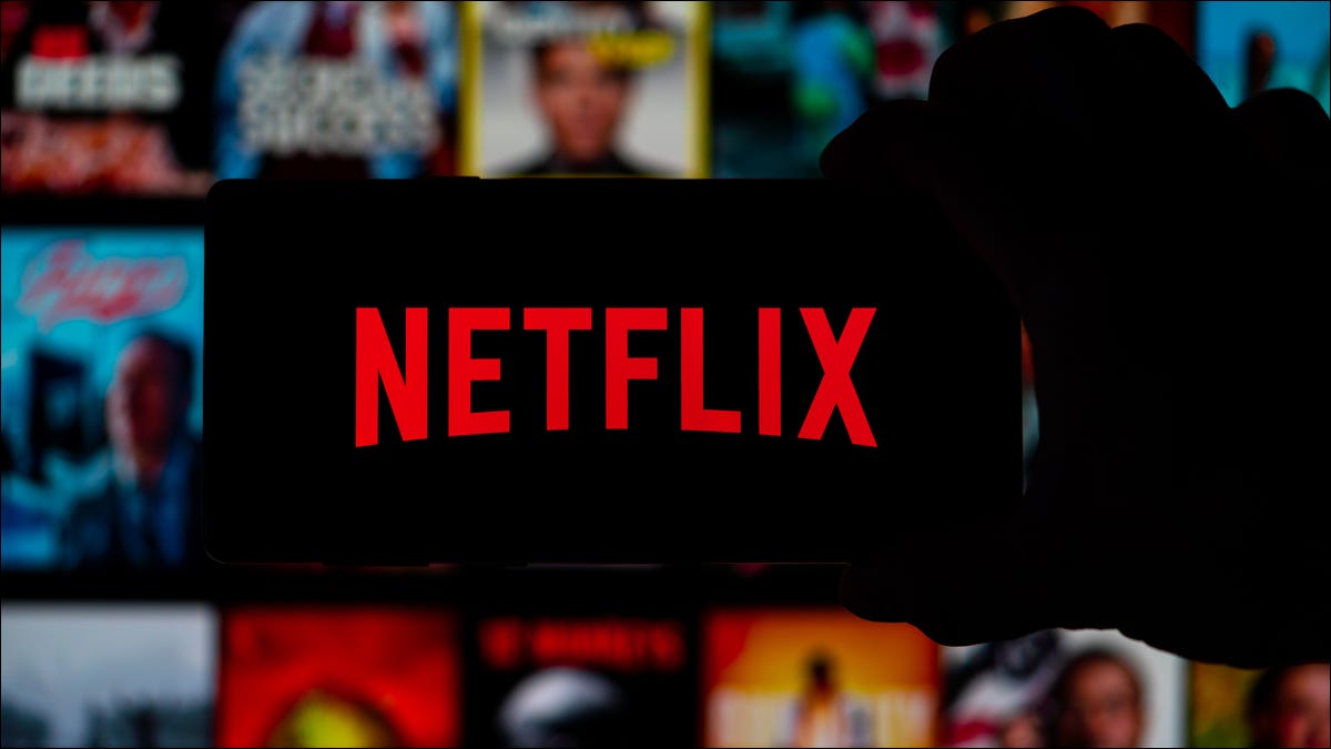 Pessoa segurando um telefone com o logotipo da Netflix nele