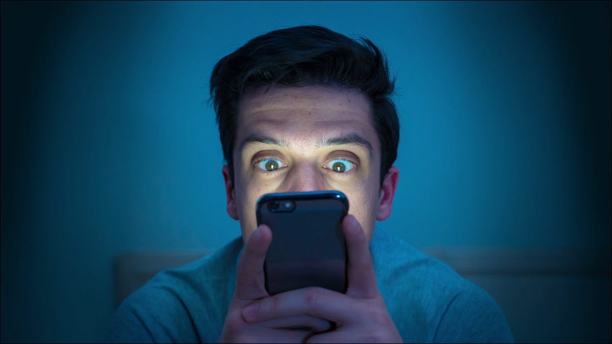 Homem com medo olhando para smartphone