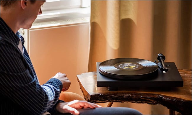 pessoa ouvindo vinil no toca-discos pro-ject