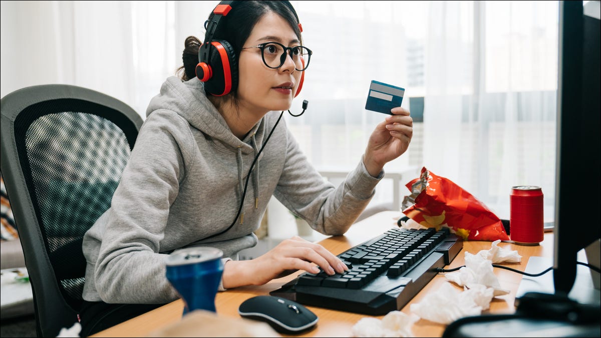 Um jogador com um cartão de crédito na frente de um PC para jogos.