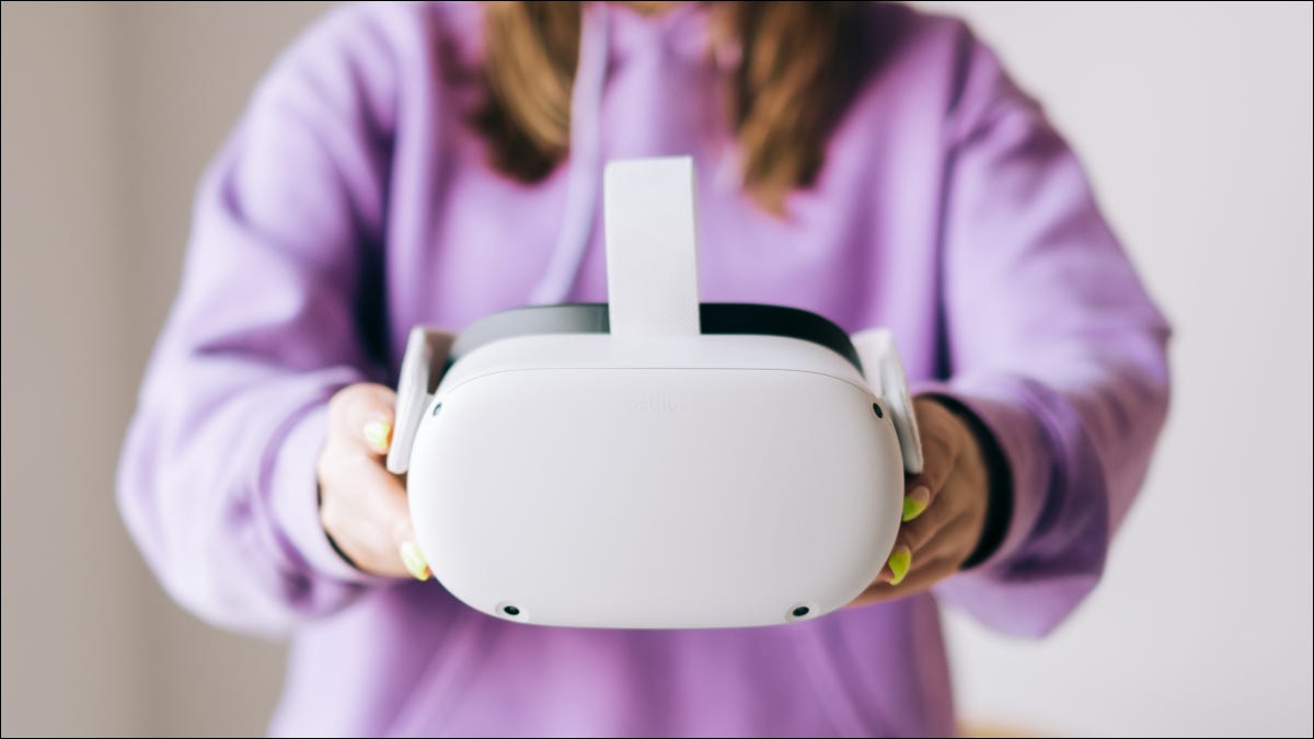 Uma mulher segurando um headset de realidade virtual Oculus Quest 2.