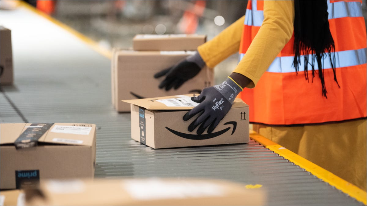 Um funcionário da Amazon manuseando um pacote em uma esteira rolante.