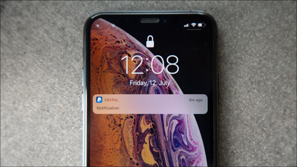 A tela de bloqueio de um iPhone com uma notificação do PayPal.