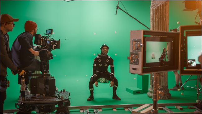 Uma pessoa em uma roupa de captura de movimento sendo filmada em um estúdio de cinema.
