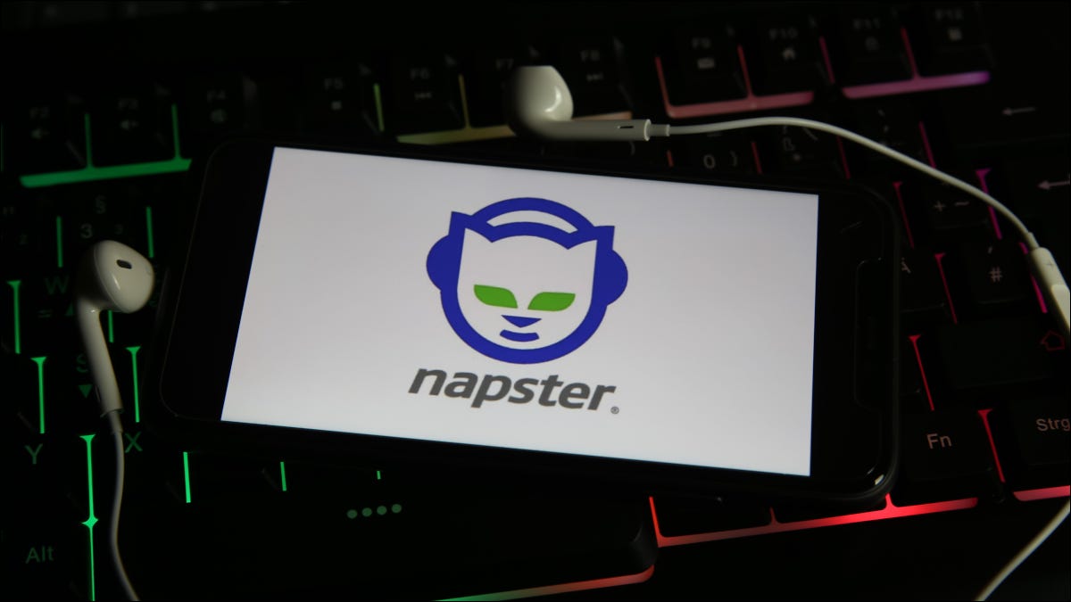 Smartphone mostrando o logotipo do Napster e cercado por fones de ouvido conectados.