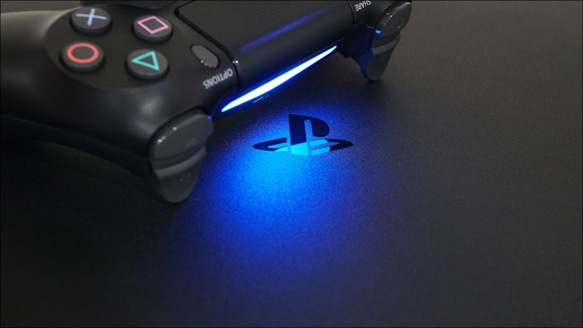 Logo PlayStation em um PS4, em luz azul lançada por um controle