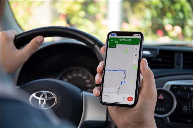 Uma pessoa navegando em um carro com o Google Maps em um iPhone.