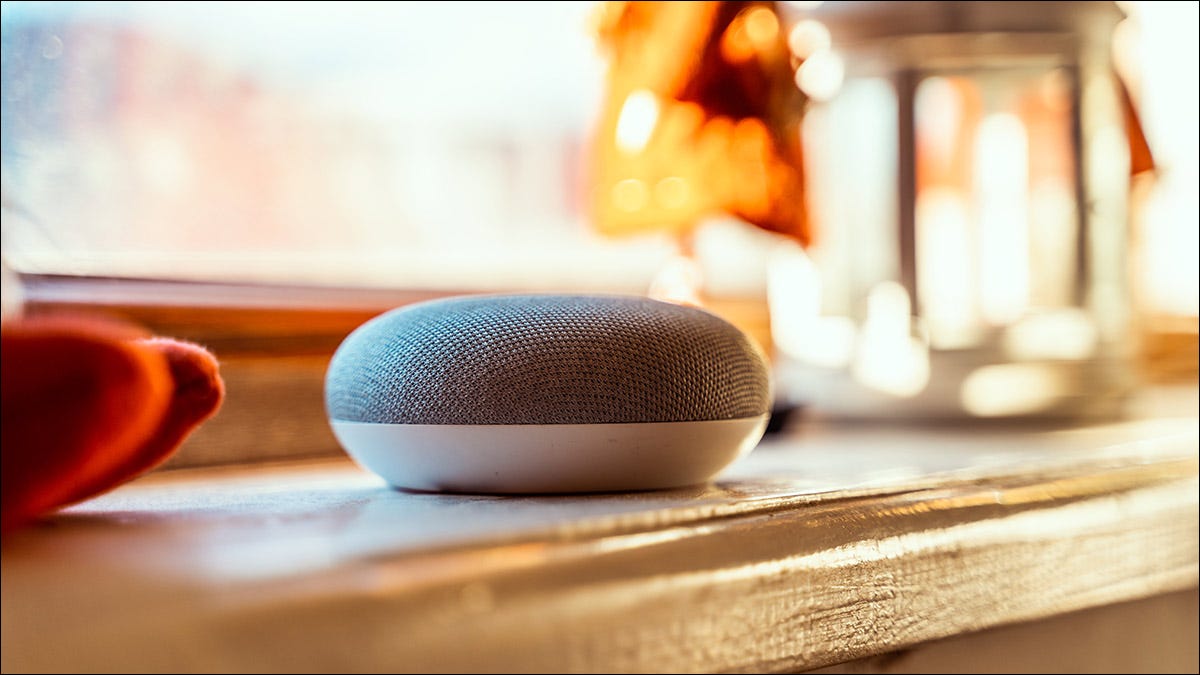 Um alto-falante Google Nest Mini sobre uma lareira.