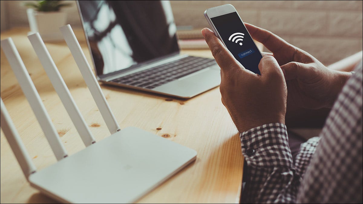 Uma pessoa conectando seu smartphone ao roteador Wi-Fi doméstico.