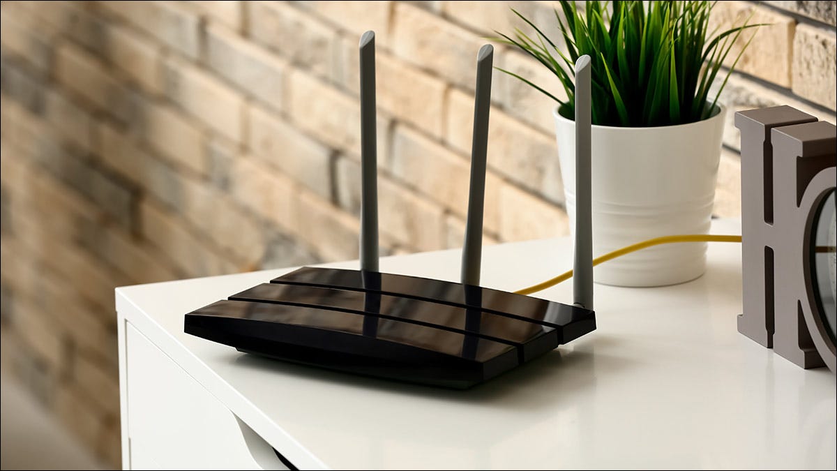 A Wi-Fi router sitting on a piece of furniture in an apartment.