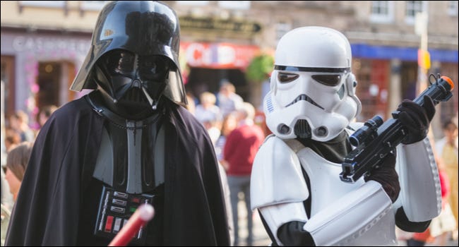 Duas pessoas fazendo cosplay de Darth Vader e um personagem Stormtrooper da franquia Star Wars.