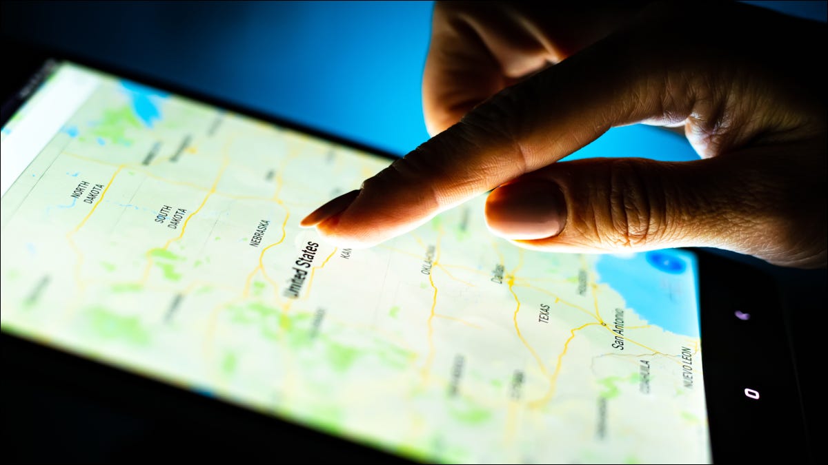 Close do dedo de uma pessoa tocando um mapa em uma tela de tablet.