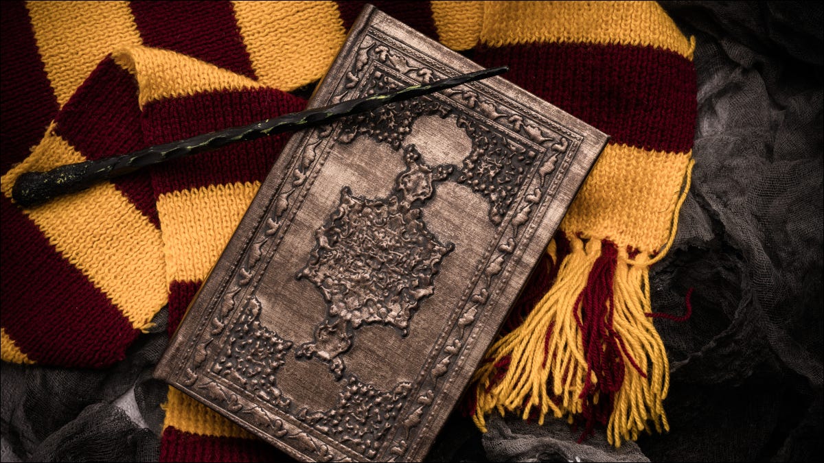 Uma coleção de recordações do tipo Harry Potter, incluindo uma varinha, um livro e um cachecol.