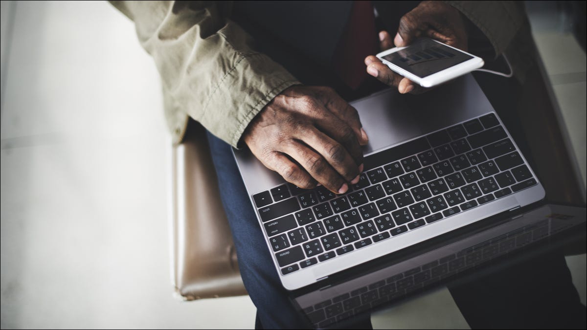 Viajante usando um smartphone e laptop juntos.