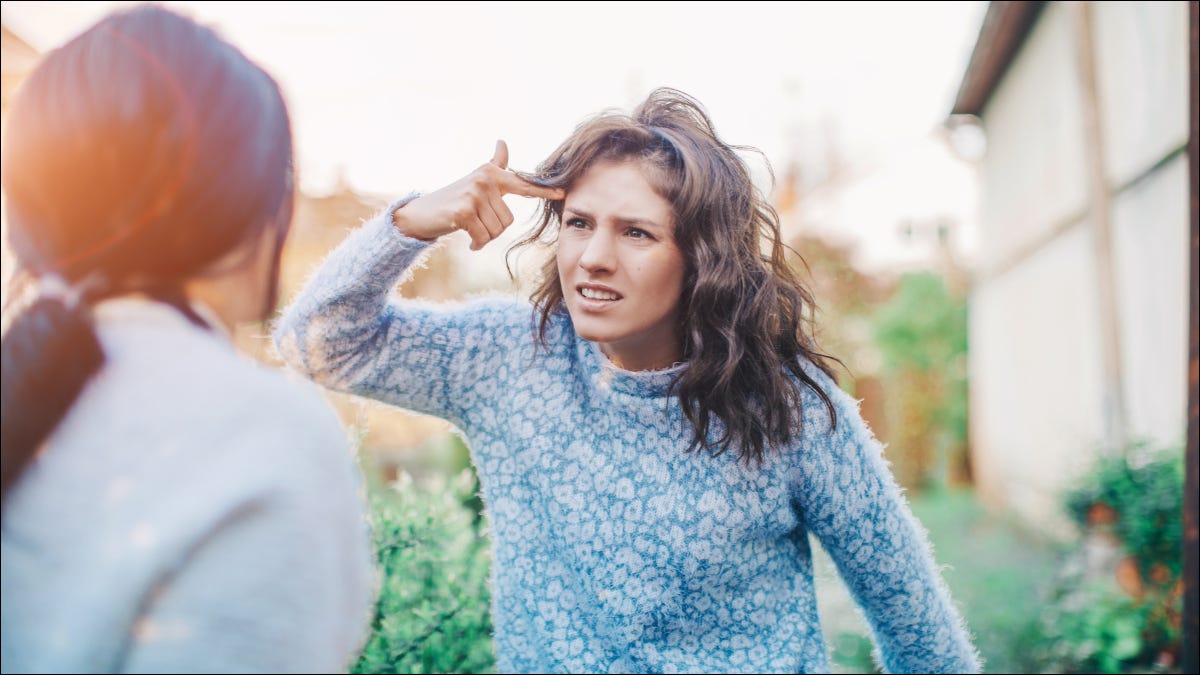 Duas mulheres discutindo, com uma apontando para a testa.