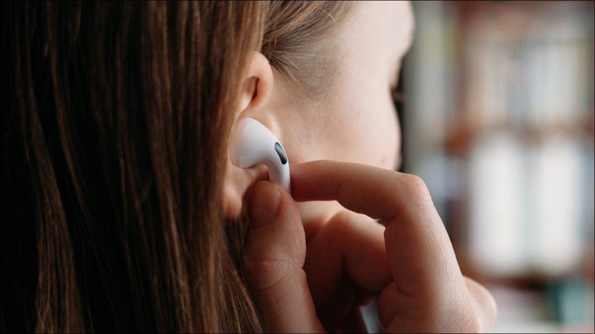 Mulher colocando Apple Airpods no ouvido