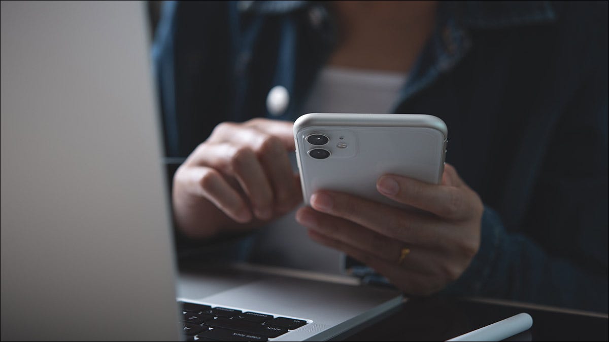 Alguém usando seu iPhone e laptop em uma conexão Wi-Fi.