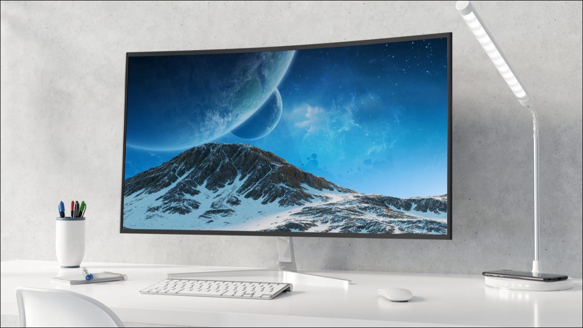 Uma configuração de desktop minimalista com um monitor de computador curvo.