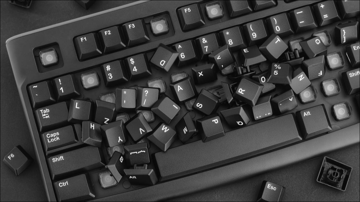 Um teclado com suas teclas removidas e espalhadas.