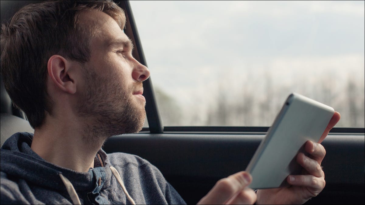 Homem em um carro usando um tablet.
