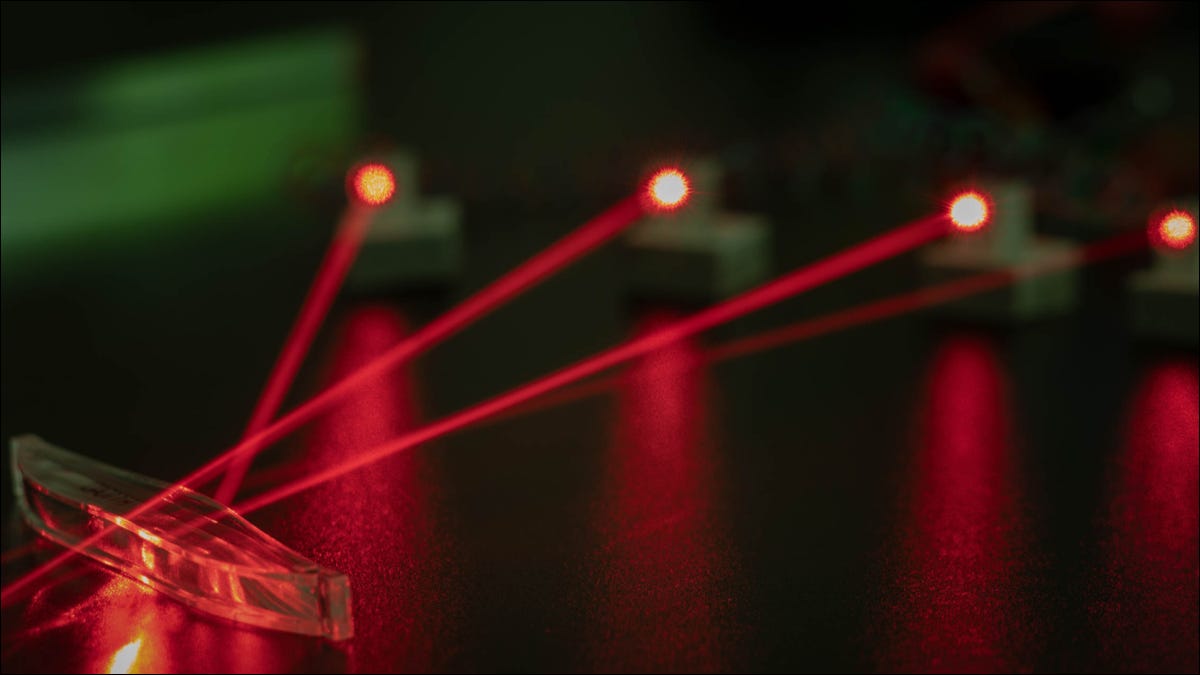 Quatro lasers vermelhos instalados em um laboratório fotônico.