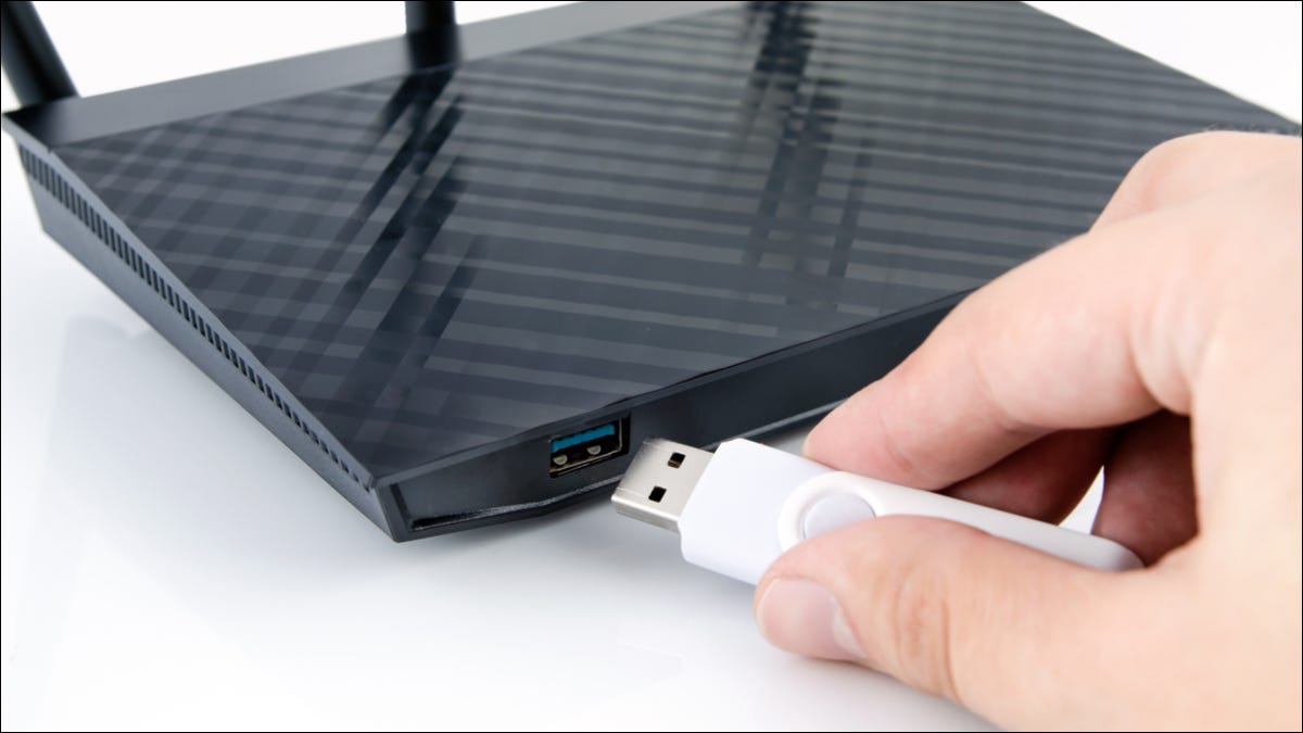 Pessoa inserindo uma unidade USB em um roteador de internet.
