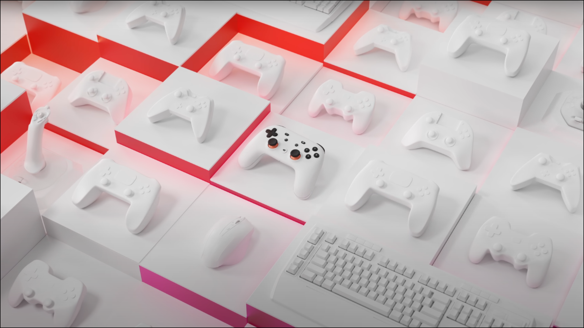 Controlador do Google Stadia sentado entre os shells do controlador e do teclado em branco