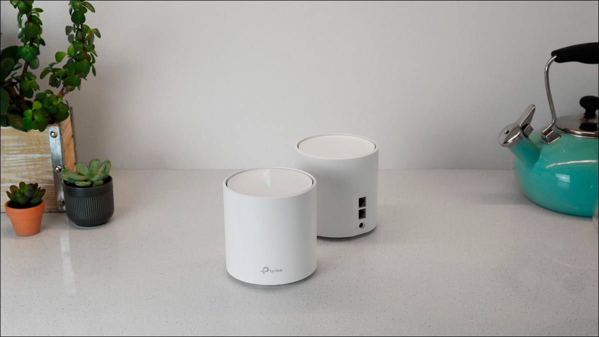 Dois nós Wi-Fi de malha TP-Link sentados em um balcão de cozinha.