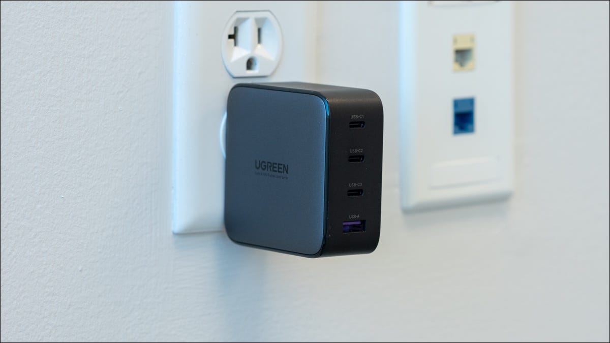 Carregador UGREEN Nexode 100W conectado à parede com a marca da empresa mostrando