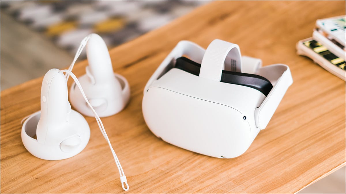 Um fone de ouvido e controladores Meta Quest 2 VR em uma mesa da sala de estar.