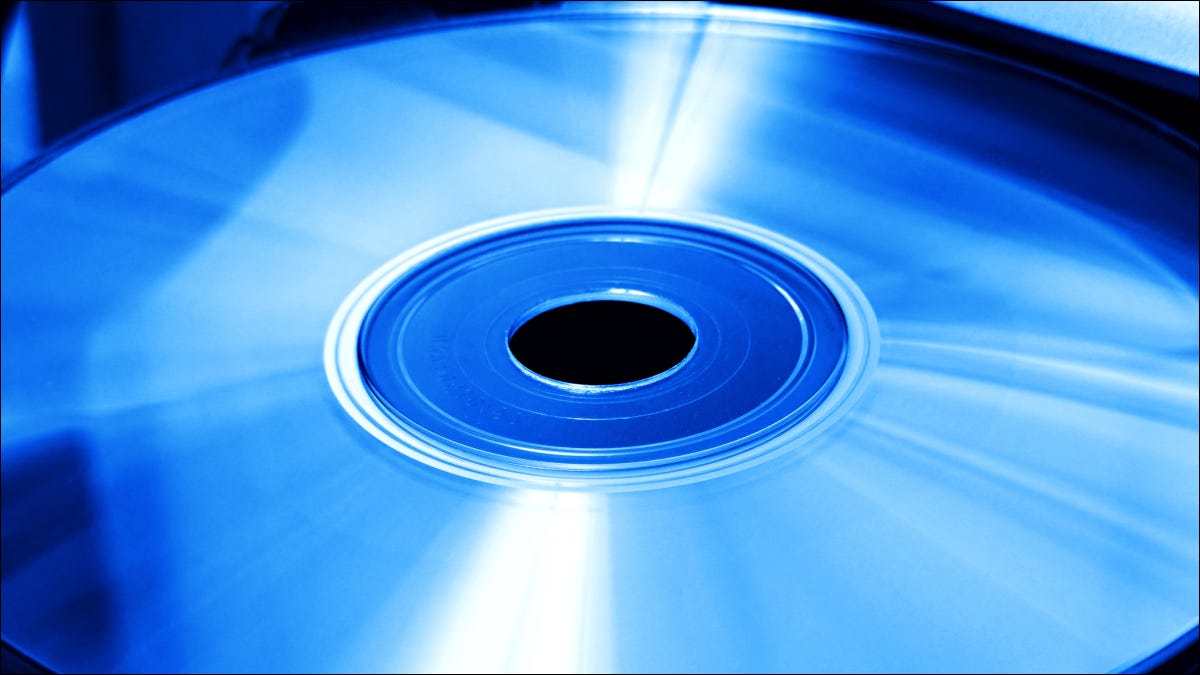 Um disco óptico em uma unidade de disco sob luz azul.