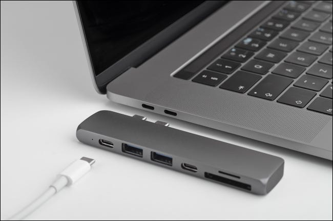 Um hub USB tipo C para um laptop com várias portas de cabo e leitor de cartão.