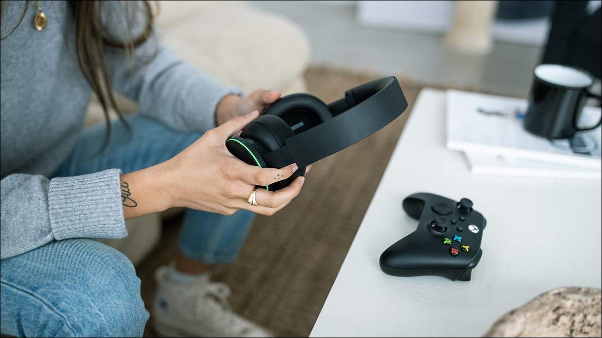 Person holding Xbox Wireless Headset near controller