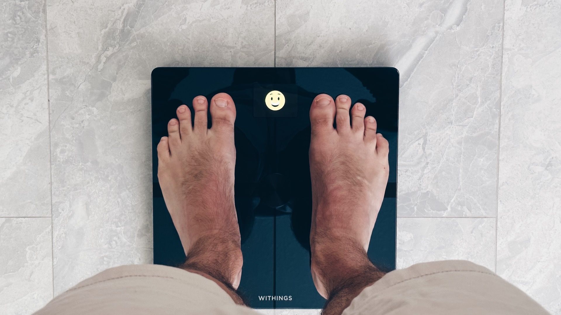 Mostrando dois pés na balança Withings Body Smart em um banheiro