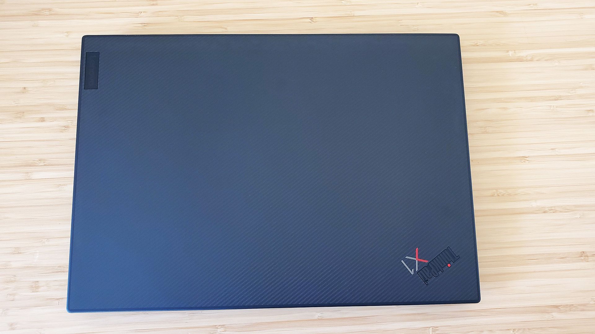 O laptop Lenovo ThinkPad X1 Extreme Gen 5 fechado sobre uma mesa.